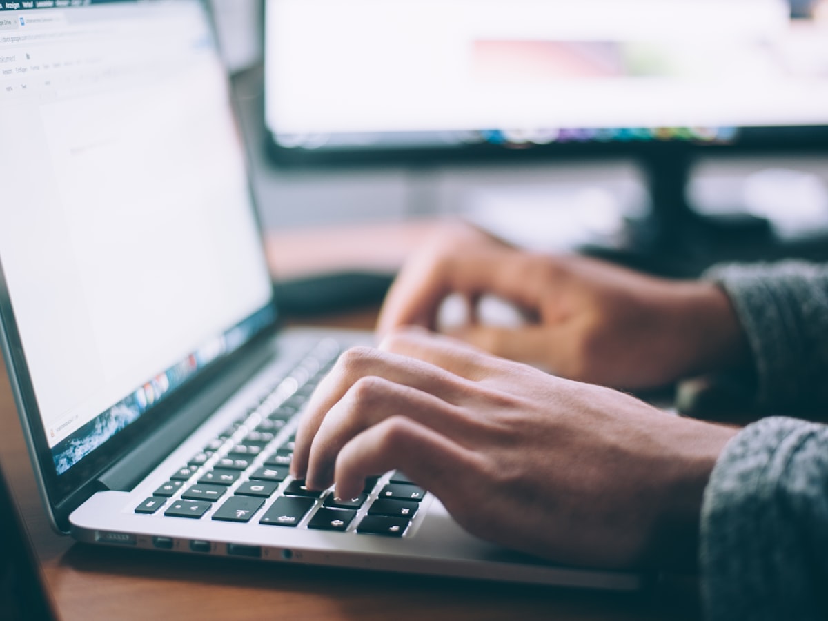 Professional working at a laptop with organised notes on the desk